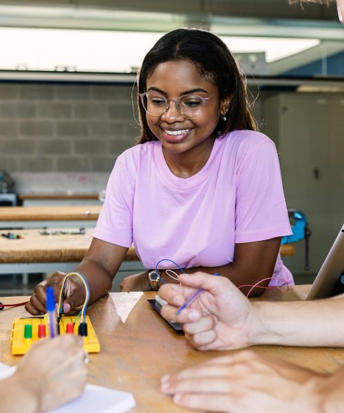 Multiracial students learning electronic at technology lesson - Group of teenager people building and programming electric circuits together in classroom